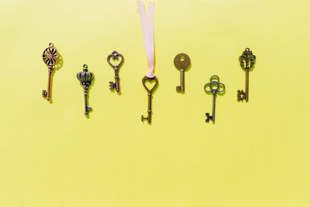 Bunch of keys, steel house keys on yellow background.a lot of different keys isolated.Valentines unlock love concept.Copy space - Photo, Image