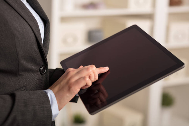 Mulher de negócios usando tablet em um ambiente acolhedor
 - Foto, Imagem