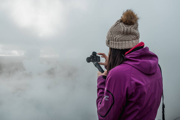 женщина фотографирует туманный скандинавский пейзаж, Исландия
 - Фото, изображение