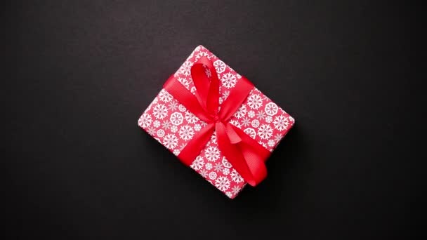 Κόκκινο δώρο κουτί με κόκκινο τόξο στον μαύρο πίνακα, το top view - Πλάνα, βίντεο