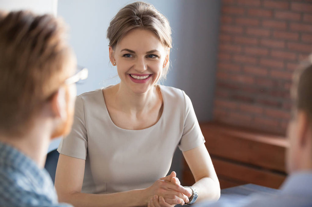 Confident millennial businesswoman smiling looking at male partn - Foto, afbeelding