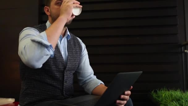 Freiberufler Geschäftsmann arbeitet am Laptop mit Diagrammen auf dem Bildschirm im Café und trinkt Kaffee. Spurensuche und aufschlussreicher Schuss - Filmmaterial, Video
