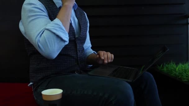 フリーランサー実業家カフェで画面上の図とのラップトップに取り組んで、コーヒーを飲むと、電話で話しています。追跡と明らかにショット - 映像、動画