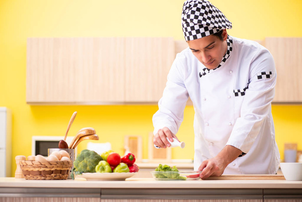 Nuori ammattilainen kokki valmistelee salaattia kotona - Valokuva, kuva