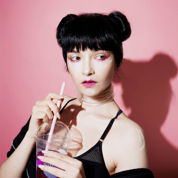 Cyber girl. Beautiful young woman, futuristic style. Portrait of a trendy girl drinking soda - Fotó, kép