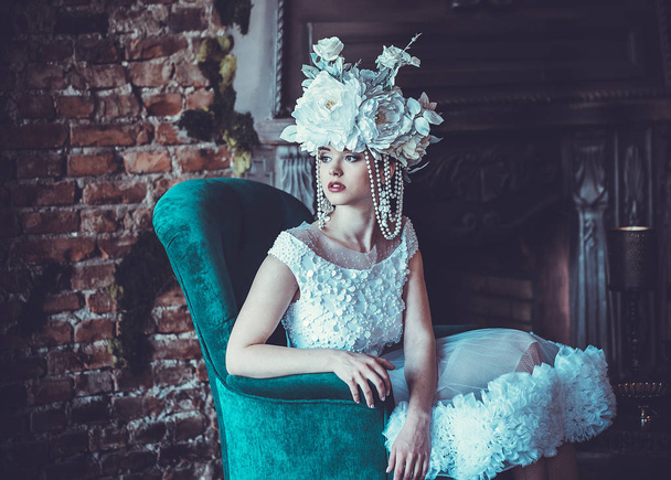Beautiful bride sits on a chair. Luxury palace. - Fotoğraf, Görsel