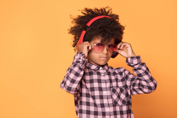 African american little man in fashionable shirt. Studio shot. Young boy posing on yellow background. - 写真・画像
