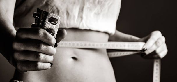 Kaunis ja vahva naisten abs metri ja pillereitä. Kuva mustavalkoinen tyyli
 - Valokuva, kuva