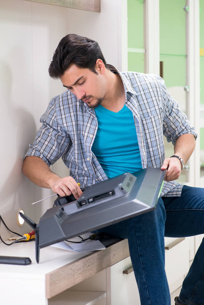 Young man husband repairing tv at home  - Photo, Image