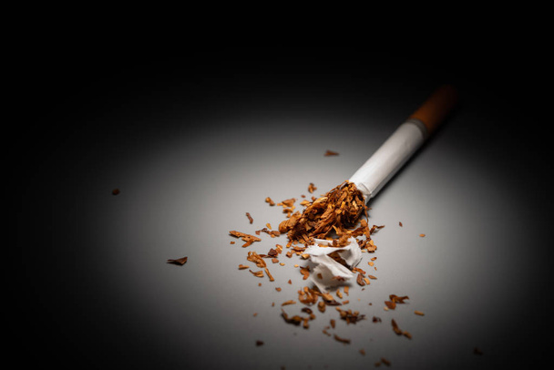 cigarette avec le haut déchiré mis en évidence dans l'obscurité
 - Photo, image