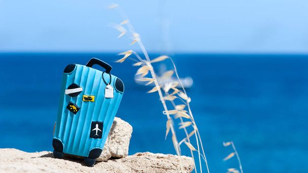 Concept travel to the sea. Stylish suitcase against the blue sea. Space for the text - Foto, afbeelding