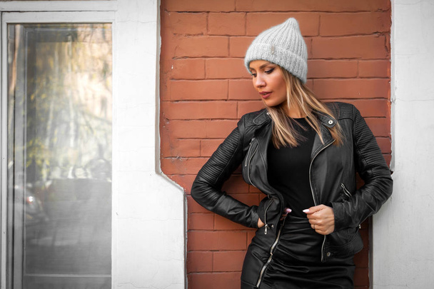 Retrato de estilo de vida de moda de mulher na moda jovem vestida com casaco preto, chapéu de malha cinza posando, rindo e sorrindo na cidade velha, moda de rua de outono. retrato de mulher alegre
 - Foto, Imagem