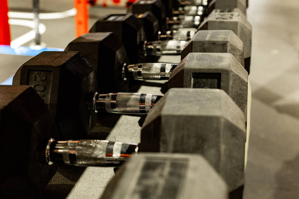 Черные резиновые гантели. Шестиугольный тяжелый набор веса используется для серьезных хардкор тренажерный зал тренировки, кросс-фитнес тренировки и тренировки процедур
 - Фото, изображение