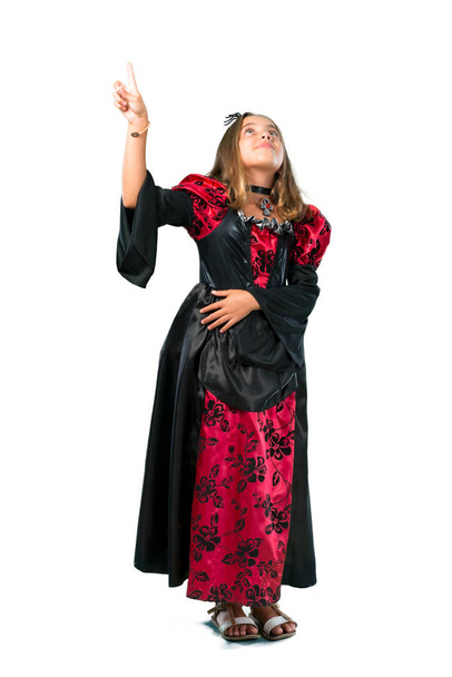 A full-length shot of a Blonde child dressed as a vampire for halloween holidays pointing with the index finger a great idea isolated on white - Zdjęcie, obraz