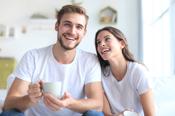 Cheerful young couple in the morning at home in the living room. - Foto, Imagem