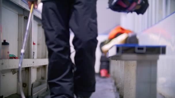 Giocatore di hockey in pattini passeggiando per la zona per i giocatori sostitutivi allo stadio di hockey e mettendo il casco in panchina
 - Filmati, video