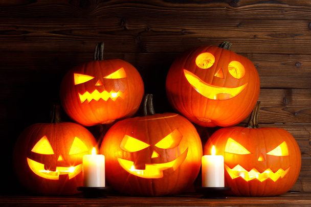 Group of Halloween pumpkin head jack o lantern and candles on dark wooden background - Zdjęcie, obraz