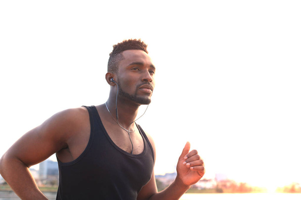 Africký muž v sportovní oblečení spuštěn při cvičení, v pláž venkovní portrét, při západu slunce nebo východu slunce. Běžec. - Fotografie, Obrázek