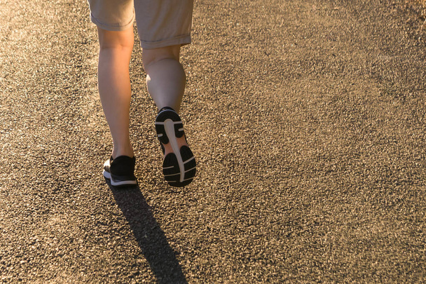 Aika urheilullinen nainen juoksemassa auringonnousun valossa. Fitness naaras juoksija jalat maaseudulla trail
. - Valokuva, kuva