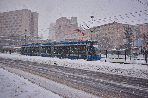 Zima w mieście. Tramwaje w stacji podczas obfitych opadów śniegu. - Zdjęcie, obraz