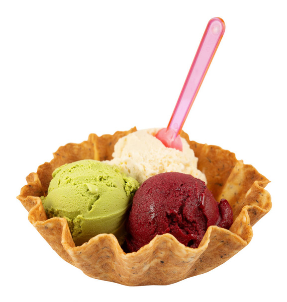 Три шарика натурального органического фруктового мороженого в вафельной чашке с пластиковой ложкой, изолированной на белом. Популярная летняя еда
. - Фото, изображение