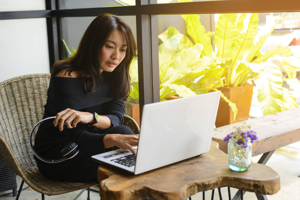 Jeune femme travaillant avec un ordinateur portable assis dans un café
 - Photo, image