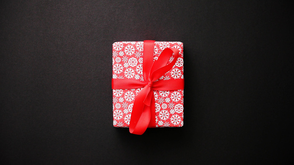 Coffret cadeau rouge avec noeud rouge sur table noire, vue de dessus
 - Photo, image