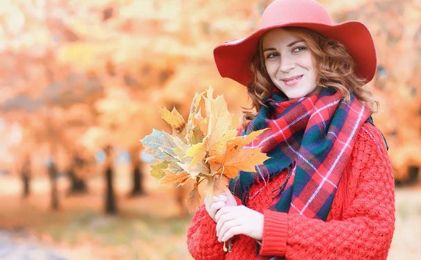 Girl in autumn city park in leaf fall. Young beautiful mother wi - Photo, Image