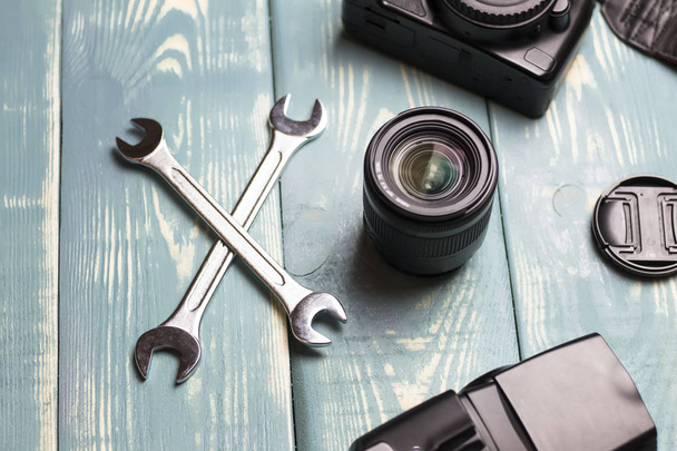 two keys and lens on wooden background. Camera repair and lens. Bad repair. - Foto, immagini