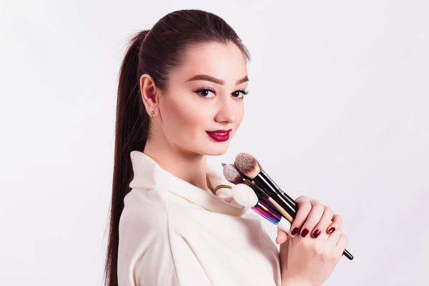 The face of a beautiful girl and make-up brush on white backgrou - Photo, Image
