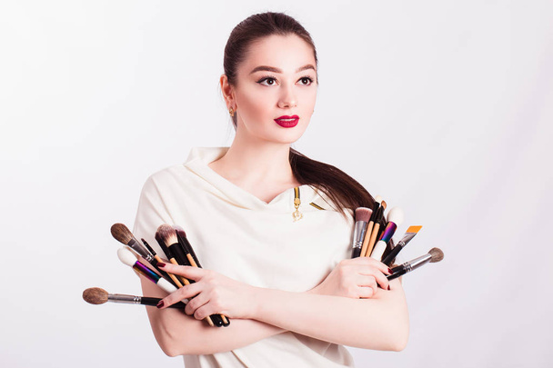 The face of a beautiful girl and make-up brush on white backgrou - Foto, afbeelding