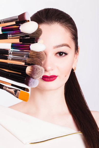 The face of a beautiful girl and make-up brush on white backgrou - 写真・画像