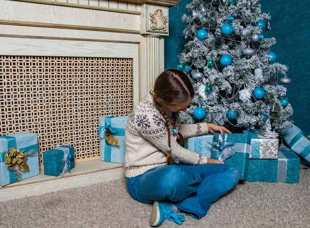 teenager girl hold presents gift box on Christmas tree background - Fotografie, Obrázek