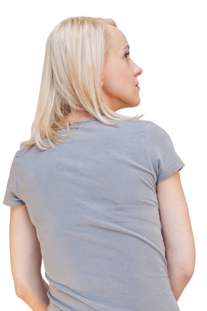 Rückseite Porträt einer sitzenden jungen blonden Frau mit grauem T-Shirt, die nach rechts schaut. Rücksicht auf Menschen. ausgeschnitten auf weißem Hintergrund. - Foto, Bild