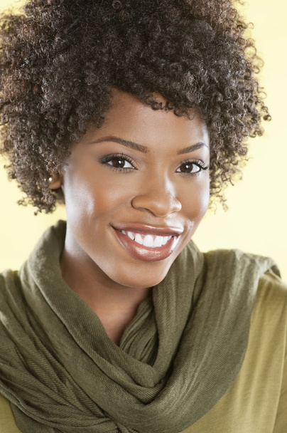Portrait of an African American woman smiling with a stole round her neck over colored background - Foto, Bild