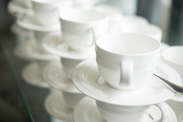 Tazze bianche per bevande calde impilate sul tavolo in hotel
 - Foto, immagini