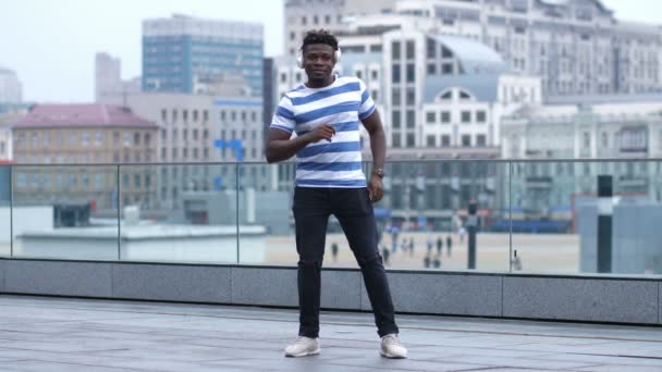 Africano americano hombre en auriculares bailando al aire libre
 - Metraje, vídeo