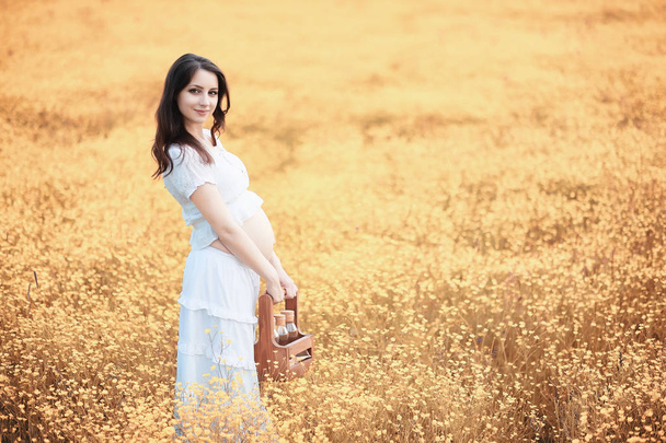 Pregnant woman in nature for a walk in the autumn - Foto, Imagen