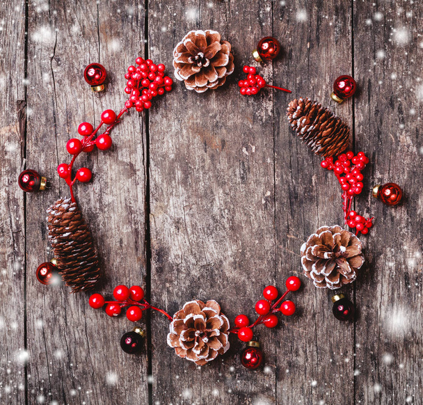 Çam dalları, koniler, koyu ahşap arka plan üzerinde kırmızı süslemeleri Noel çelenk. Noel ve mutlu yeni yıl kompozisyon. Düz yatıyordu, en iyi görünümü - Fotoğraf, Görsel