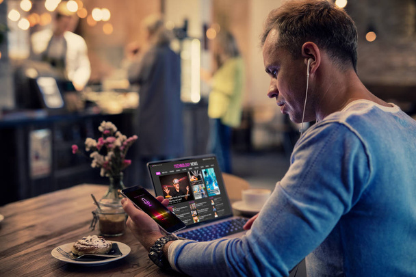 Человек, использующий современные технологии, сидя в кафе
 - Фото, изображение