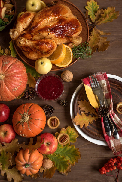 Thanksgiving Dinner background with Turkey, fall leaves, seasonal autumnal fruits, decor and table setting, top view. - 写真・画像