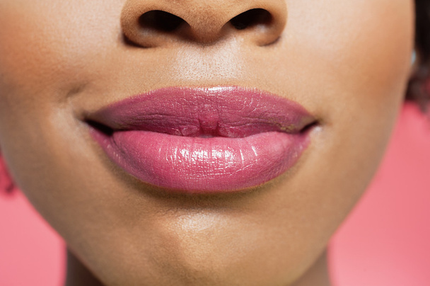 Close-up view of an African American woman's red lips over colored background - Foto, immagini