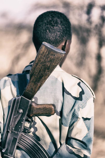  áfrica na terra da Etiópia um soldado negro e sua arma olhando o pensionista
 - Foto, Imagem