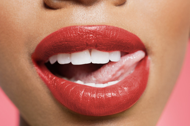Cropped image of woman licking red lipstick - Zdjęcie, obraz
