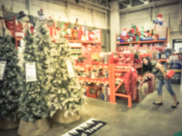 Bewegung verschwommen Kunden einkaufen für künstliche Weihnachtsbaum mehrfarbige Lichter im Baumarkt in Texas, USA. defokussiert klassisch, dekoriert Weihnachten Farbwechsel Kränze, Saiten Bokeh Ornamente - Foto, Bild