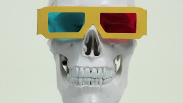 cráneo con gafas de película 3d sobre fondo blanco
 - Metraje, vídeo