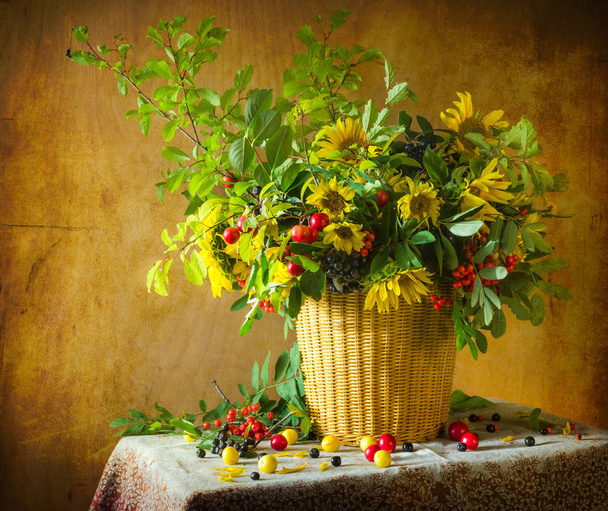 Still life with bouquet of twigs of plum, sunflower, elderberry and rowan - Photo, Image