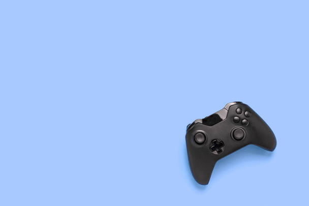 Gamepad on a blue background. Concept of the game in the console or computer. Rest after work. Cybersport. Flat lay, top view. - Photo, Image