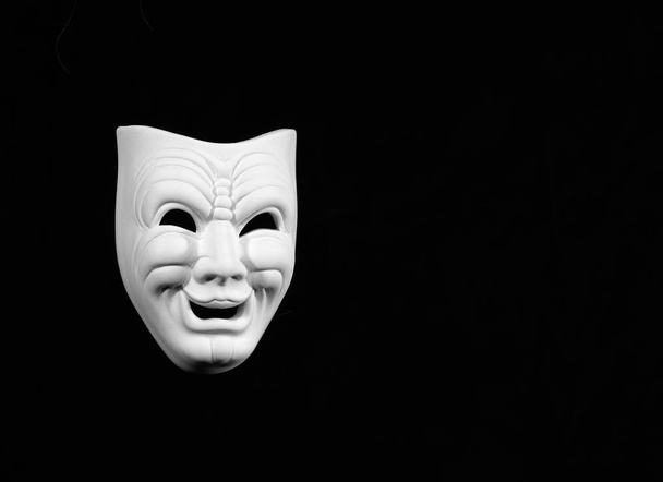 masque de théâtre exprimant la comédie, masque blanc sur fond noir avec espace libre pour le texte
 - Photo, image