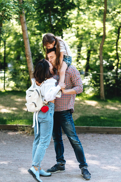 Happy young parents kiss in the park. - Valokuva, kuva